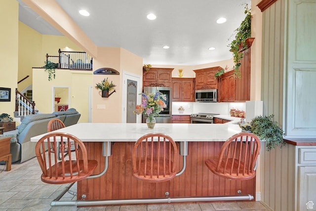 97 Hillsborough Dr, Pleasant View, UT 84414 - kitchen with appliances with stainless steel finishes, light countertops, a kitchen bar, a peninsula, and recessed lighting