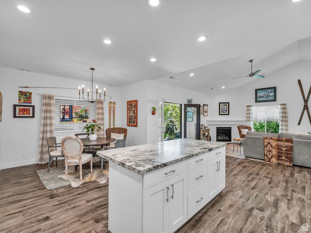 354 E 370 S, Kamas, UT 84036 - kitchen featuring healthy amount of natural light, wood finished floors, vaulted ceiling, a fireplace, and white cabinetry