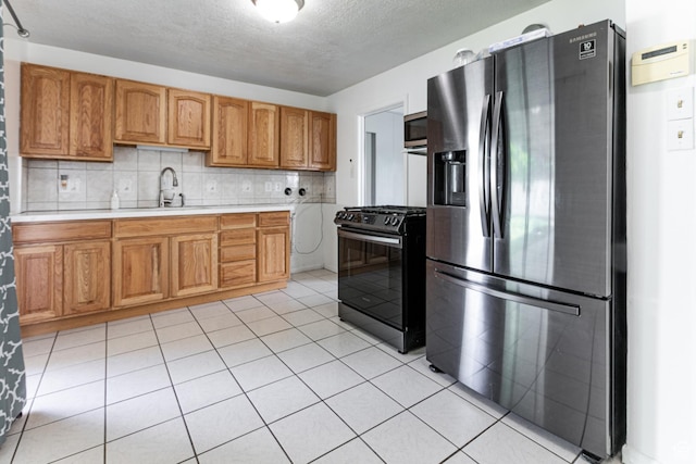 317 Highland Dr, Tooele, UT 84074 - kitchen featuring stainless steel appliances, light countertops, a textured ceiling, brown cabinets, and backsplash