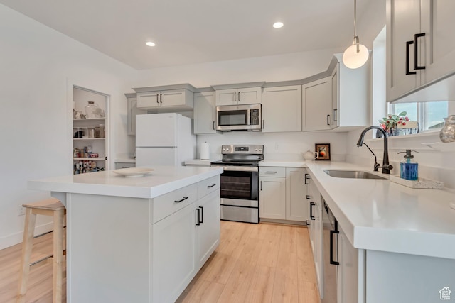 7256 N Green Pasture Ln, Eagle Mountain, UT 84005 - kitchen with stainless steel appliances, a kitchen island, light wood-style floors, light countertops, and recessed lighting