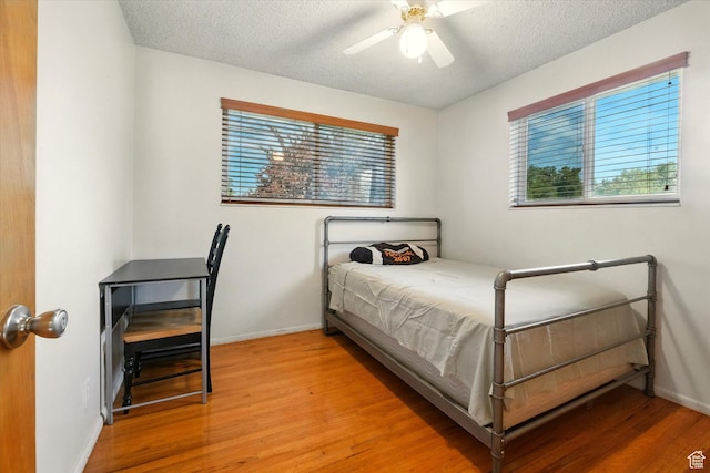 2280 N 800 E, North Logan, UT 84341 - bedroom featuring light wood-style floors, multiple windows, a textured ceiling, and ceiling fan