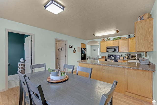 815 N 100 E Unit 5, Brigham City, UT 84302 - dining room featuring light wood-type flooring, arched walkways, and a textured ceiling