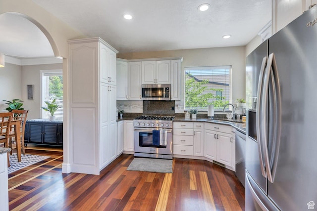 215 N Bald Mountain Dr E, Alpine, UT 84004 - kitchen with appliances with stainless steel finishes, dark wood-type flooring, arched walkways, white cabinets, and recessed lighting