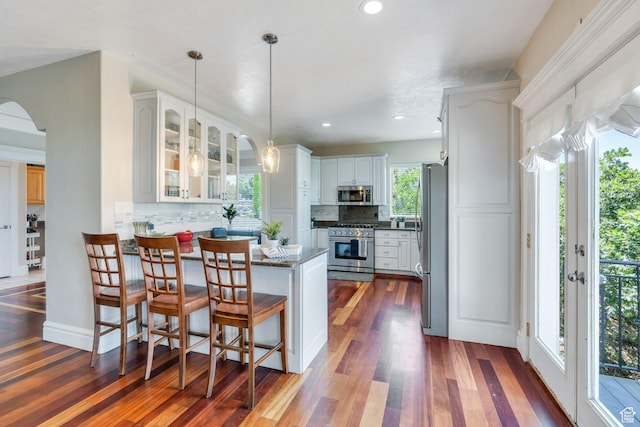 215 N Bald Mountain Dr E, Alpine, UT 84004 - kitchen featuring stainless steel appliances, a peninsula, backsplash, glass insert cabinets, and dark wood-style flooring