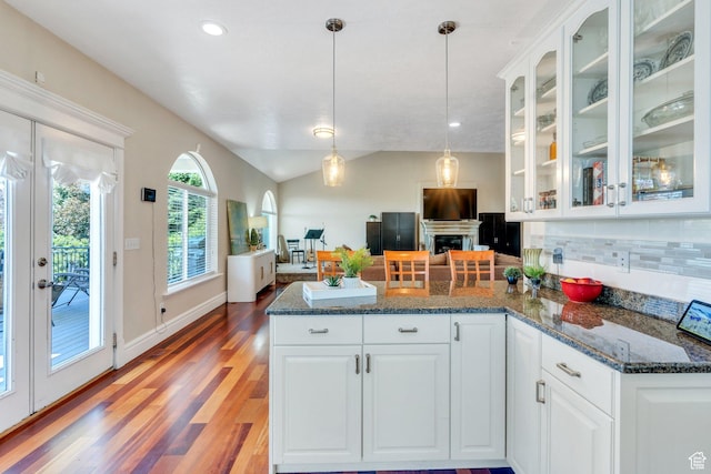215 N Bald Mountain Dr E, Alpine, UT 84004 - kitchen featuring a peninsula, backsplash, a fireplace, glass insert cabinets, and light wood-style flooring