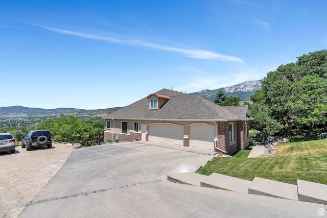215 N Bald Mountain Dr E, Alpine, UT 84004 - view of front of property with brick siding, an attached garage, a front lawn, a mountain view, and driveway