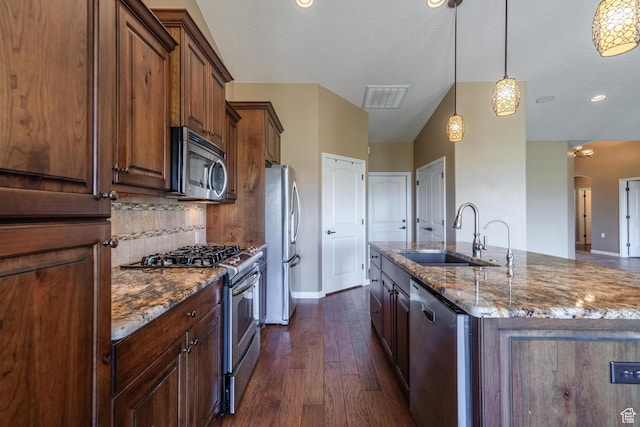 1410 W Ambassador Dr, St George, UT 84790 - kitchen featuring stainless steel appliances, dark wood-type flooring, a center island with sink, dark stone countertops, and pendant lighting
