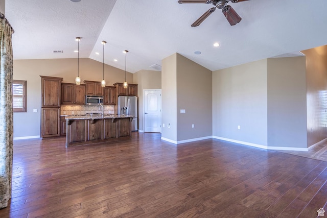 1410 W Ambassador Dr, St George, UT 84790 - kitchen featuring stainless steel appliances, a ceiling fan, a kitchen bar, a kitchen island with sink, and dark wood-style flooring