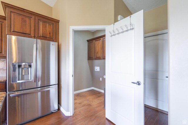 1410 W Ambassador Dr, St George, UT 84790 - kitchen featuring stainless steel fridge, light wood finished floors, brown cabinetry, and stone countertops