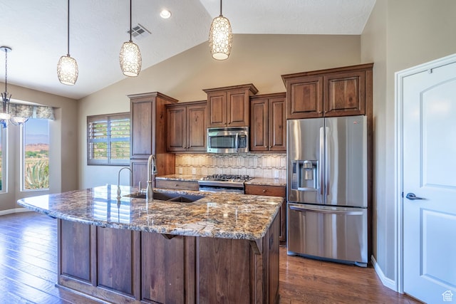 1410 W Ambassador Dr, St George, UT 84790 - kitchen with appliances with stainless steel finishes, vaulted ceiling, dark stone countertops, tasteful backsplash, and dark wood-style flooring