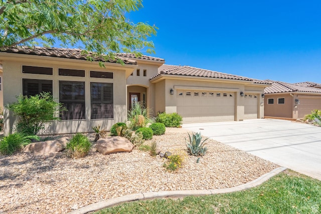 1410 W Ambassador Dr, St George, UT 84790 - mediterranean / spanish home featuring a garage, driveway, a tile roof, and stucco siding