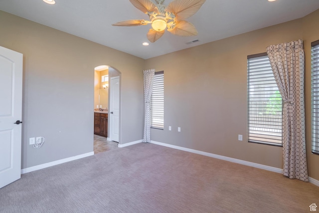 1410 W Ambassador Dr, St George, UT 84790 - unfurnished bedroom featuring arched walkways, light carpet, recessed lighting, connected bathroom, and ceiling fan