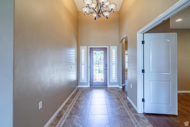 1410 W Ambassador Dr, St George, UT 84790 - foyer entrance featuring arched walkways, a chandelier, a high ceiling, inlaid floor details, and tile patterned floors
