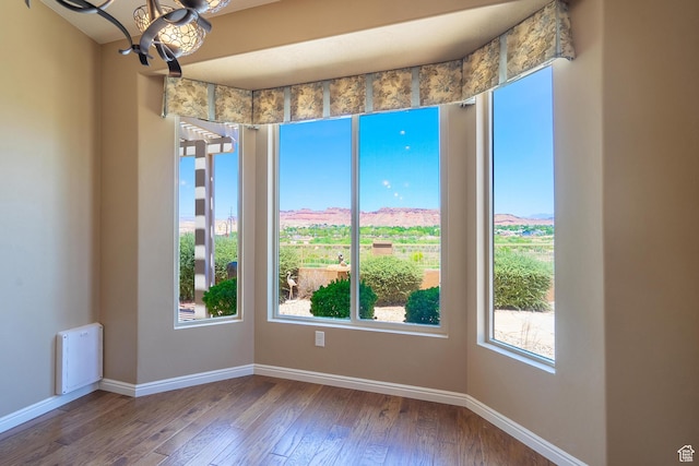 1410 W Ambassador Dr, St George, UT 84790 - empty room with plenty of natural light, hardwood / wood-style flooring, and a chandelier