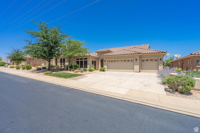 1410 W Ambassador Dr, St George, UT 84790 - mediterranean / spanish home featuring an attached garage, stucco siding, driveway, and a tile roof