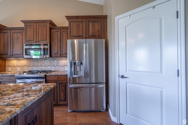 1410 W Ambassador Dr, St George, UT 84790 - kitchen featuring stainless steel appliances, decorative backsplash, dark wood-type flooring, stone counters, and vaulted ceiling