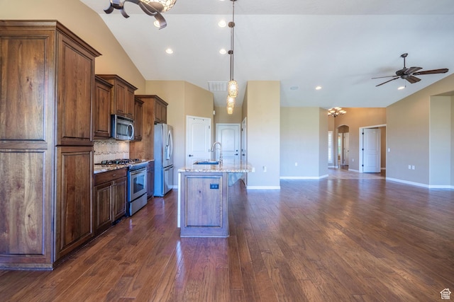 1410 W Ambassador Dr, St George, UT 84790 - kitchen with stainless steel appliances, open floor plan, decorative backsplash, an island with sink, and dark wood-type flooring