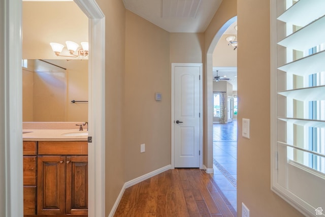 1410 W Ambassador Dr, St George, UT 84790 - hallway with wood finished floors, arched walkways, and a chandelier