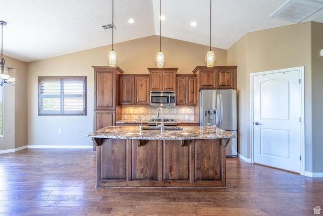 1410 W Ambassador Dr, St George, UT 84790 - kitchen with appliances with stainless steel finishes, lofted ceiling, light stone counters, a breakfast bar area, and dark wood-style flooring