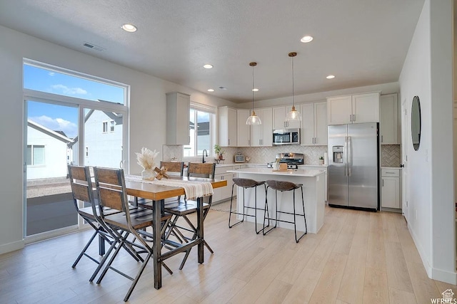 856 S 250 W, American Fork, UT 84003 - kitchen with stainless steel appliances, tasteful backsplash, a kitchen island, light wood finished floors, and recessed lighting