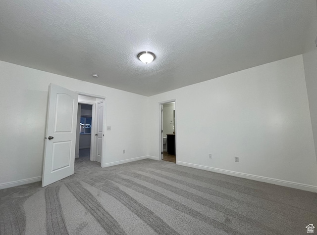 5558 W Dornton Ct, Herriman, UT 84096 - unfurnished bedroom with carpet flooring, a textured ceiling, and a walk in closet