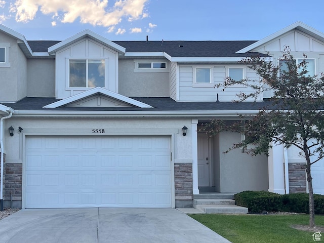 5558 W Dornton Ct, Herriman, UT 84096 - view of front of house with stone siding, driveway, an attached garage, and a shingled roof