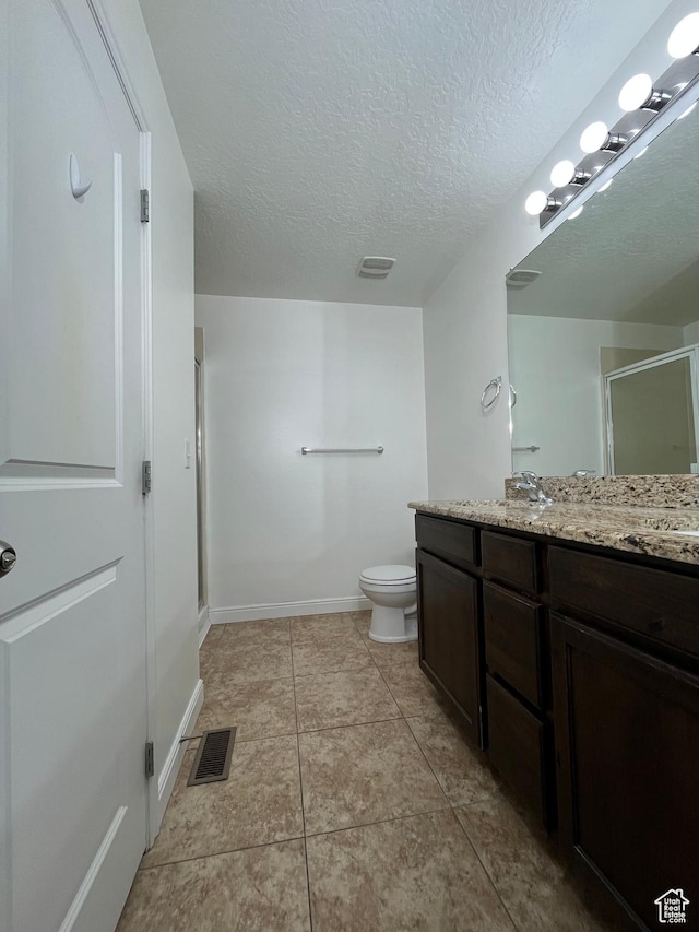 5558 W Dornton Ct, Herriman, UT 84096 - bathroom featuring vanity, a stall shower, a textured ceiling, and tile patterned floors