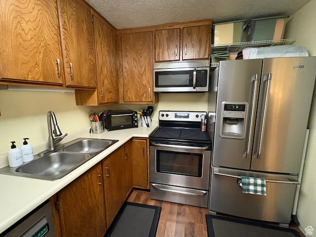 8158 S Cottonwood Hills Cir, Sandy, UT 84094 - kitchen with appliances with stainless steel finishes, brown cabinetry, dark wood-type flooring, and a textured ceiling