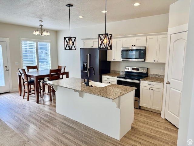 1611 N 3860 W, Lehi, UT 84043 - kitchen with stainless steel appliances, light wood-style floors, recessed lighting, a breakfast bar, and a center island with sink