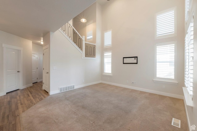1611 N 3860 W, Lehi, UT 84043 - unfurnished living room featuring a high ceiling, plenty of natural light, carpet, and stairs
