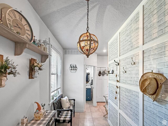 4491 Haven Rd Unit 11E, West Haven, UT 84401 - hall with a chandelier, light tile patterned flooring, and a textured ceiling