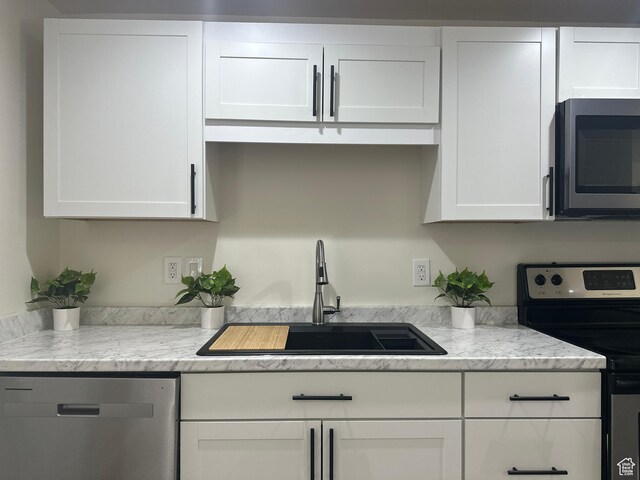 469 Canfield Dr, Ogden, UT 84404 - kitchen with appliances with stainless steel finishes, white cabinetry, and light stone counters