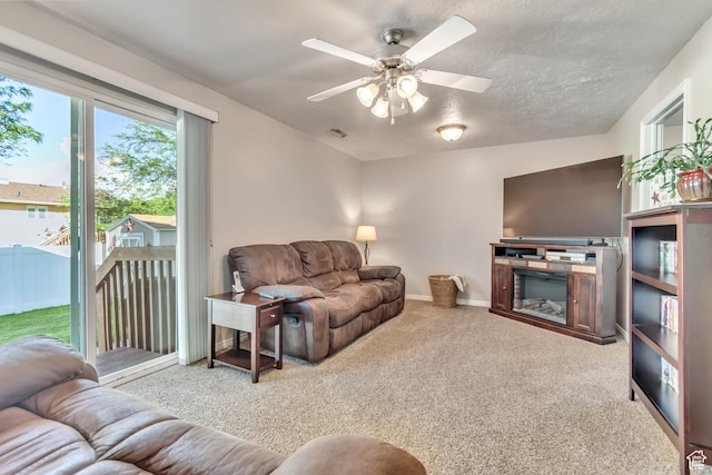 6925 S Sparrowtail Rd W, West Jordan, UT 84081 - carpeted living room with a ceiling fan and a glass covered fireplace