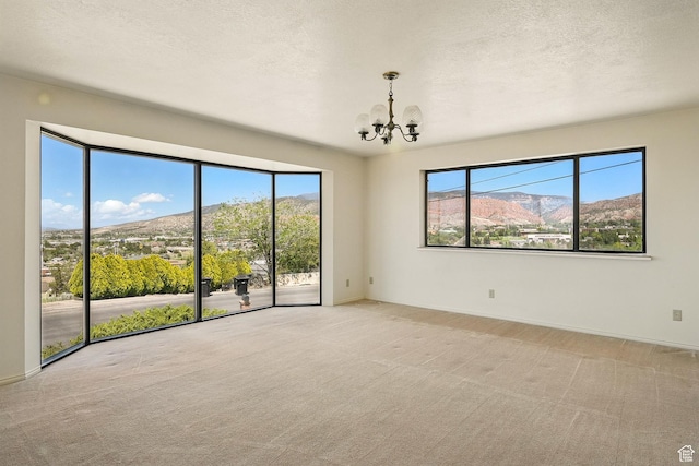 42 S Juniper Dr, Cedar City, UT 84720 - carpeted empty room featuring a chandelier, a textured ceiling, and a mountain view