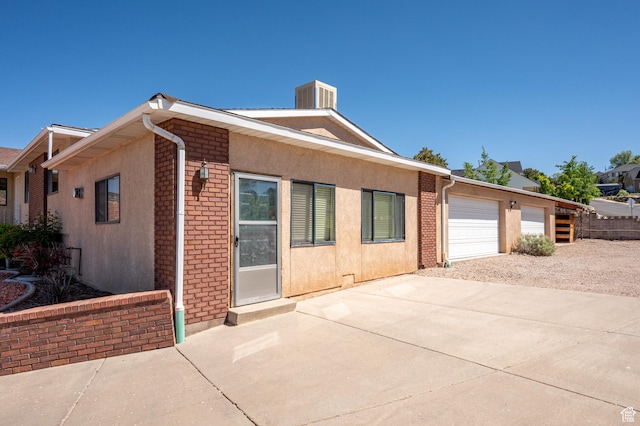 42 S Juniper Dr, Cedar City, UT 84720 - view of front of home featuring driveway, brick siding, and stucco siding