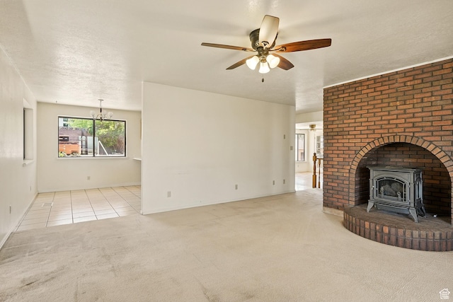 42 S Juniper Dr, Cedar City, UT 84720 - unfurnished living room with a wood stove, carpet flooring, ceiling fan, a chandelier, and tile patterned floors