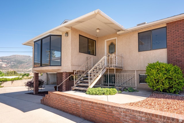 42 S Juniper Dr, Cedar City, UT 84720 - view of front of home with stucco siding, a mountain view, stairs, and brick siding