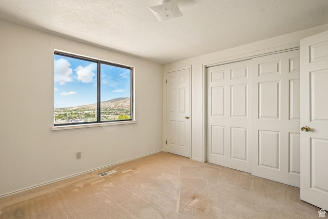 42 S Juniper Dr, Cedar City, UT 84720 - unfurnished bedroom featuring light colored carpet, a textured ceiling, and a closet