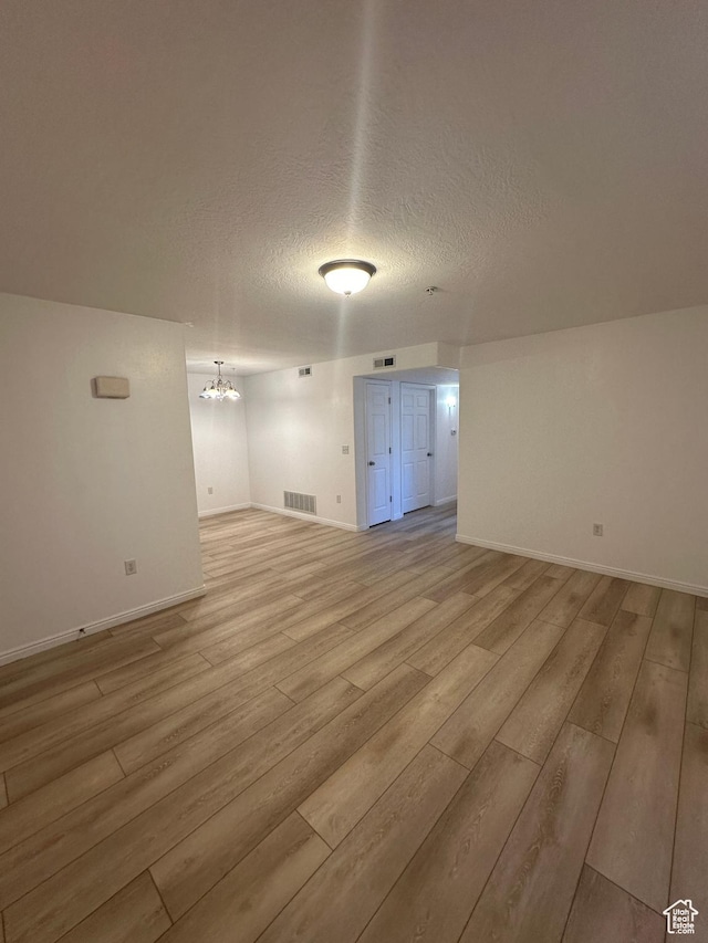 59 W Ridge Rd N, Saratoga Springs, UT 84043 - spare room with a chandelier, light wood-style floors, and a textured ceiling