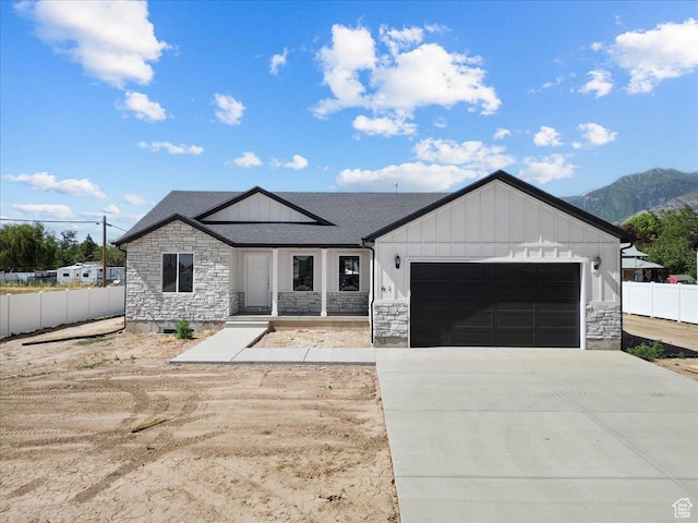 61 E 600 S, Nephi, UT 84648 - modern farmhouse style home with stone siding, board and batten siding, an attached garage, concrete driveway, and a mountain view