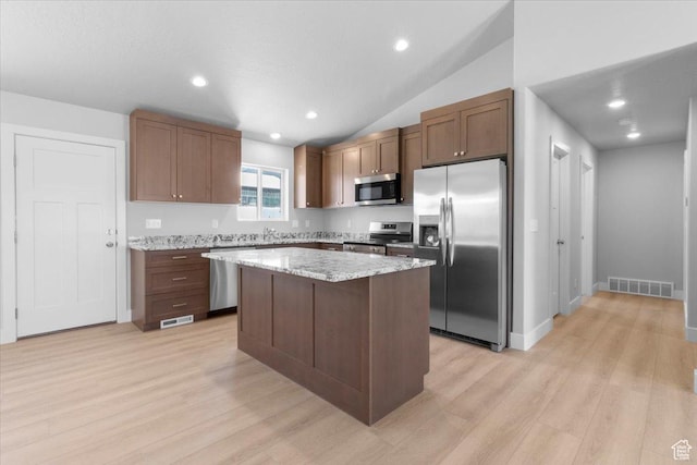 61 E 600 S, Nephi, UT 84648 - kitchen featuring appliances with stainless steel finishes, light wood-style floors, a kitchen island, light stone counters, and lofted ceiling