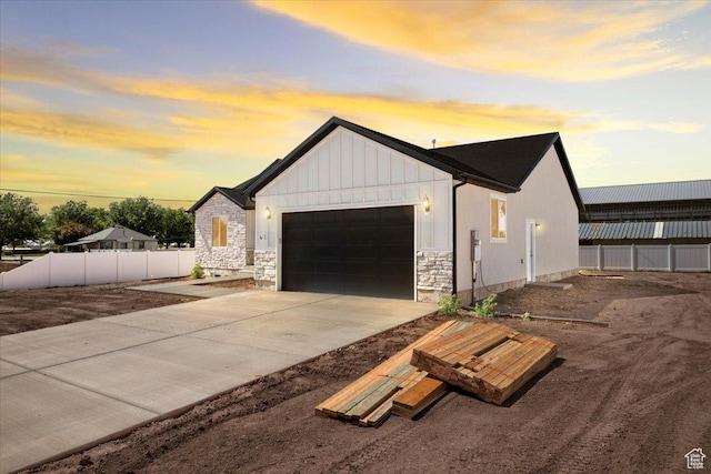61 E 600 S, Nephi, UT 84648 - view of front of home with an attached garage, stone siding, driveway, and board and batten siding