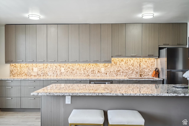 777 E S Temple N Unit 4B, Salt Lake City, UT 84102 - kitchen with freestanding refrigerator, gray cabinets, and a kitchen breakfast bar
