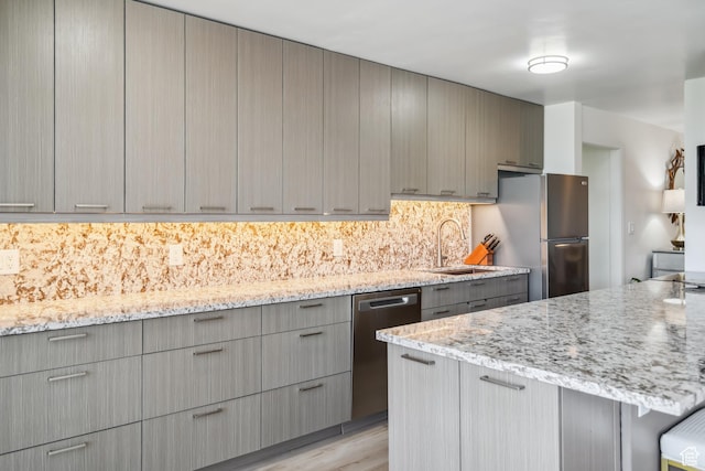 777 E S Temple N Unit 4B, Salt Lake City, UT 84102 - kitchen with stainless steel appliances, gray cabinets, light stone counters, backsplash, and light wood-style floors