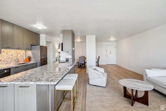 777 E S Temple N Unit 4B, Salt Lake City, UT 84102 - kitchen featuring freestanding refrigerator, open floor plan, a kitchen breakfast bar, light wood-style flooring, and a peninsula