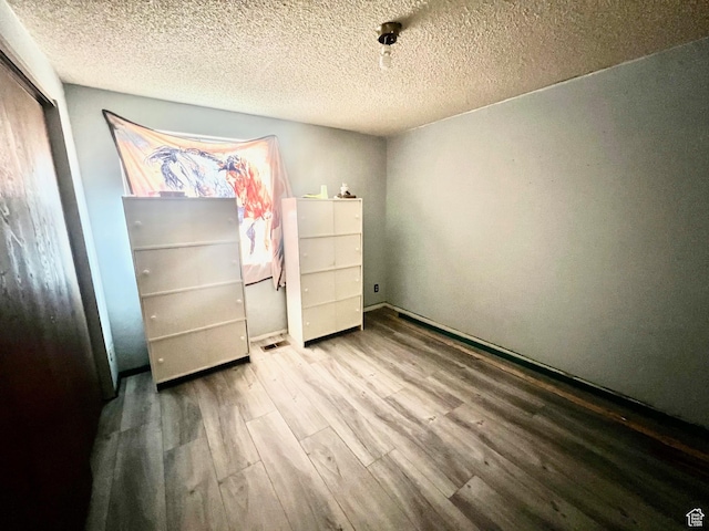 675 W 2550 S, Price, UT 84501 - unfurnished bedroom featuring wood finished floors, a closet, and a textured ceiling