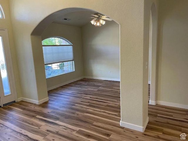 1118 E Chokeberry Dr, St George, UT 84790 - empty room featuring a ceiling fan, wood finished floors, and arched walkways