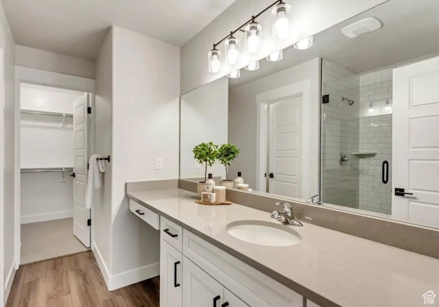 2632 N 2125 W Unit 144, Clinton, UT 84015 - bathroom featuring a shower stall, a spacious closet, wood finished floors, and vanity