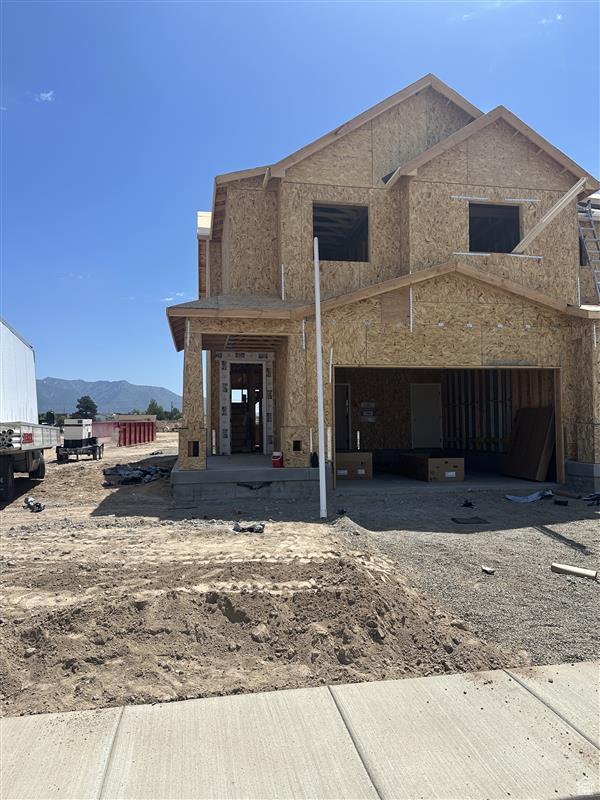 2632 N 2125 W Unit 144, Clinton, UT 84015 - back of house with a mountain view, dirt driveway, and a garage