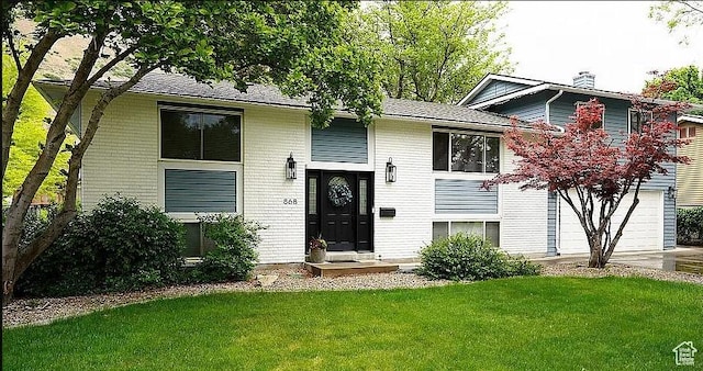 868 Medoland Dr, Brigham City, UT 84302 - bi-level home with a front yard, an attached garage, driveway, and brick siding